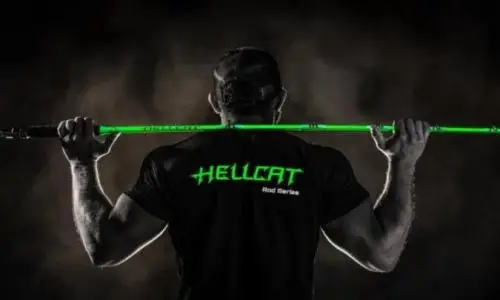 一名钓手在暗色摄影室带着 Catch The Fever 的燄绿色 HellCat 钓竿。